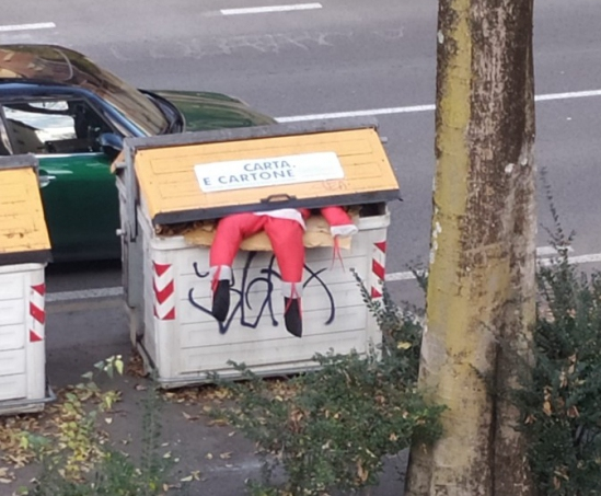 Un Babbo Natale di pezza in un cassonetto.